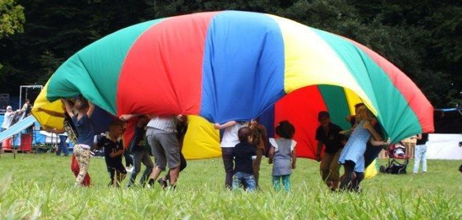 Children under colourful cloth