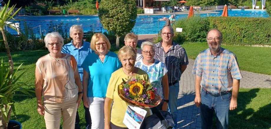 The 32,000th bather with a bouquet of flowers