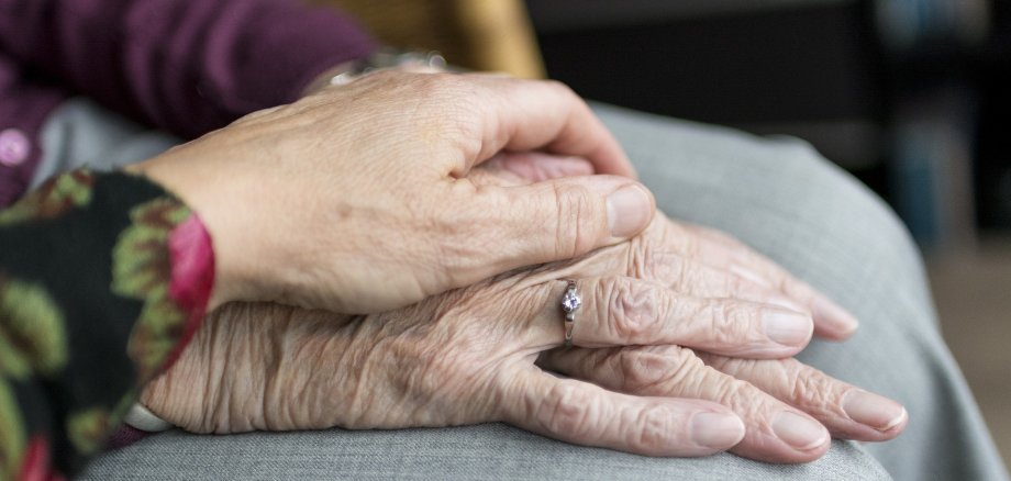 Older and younger hands touch each other