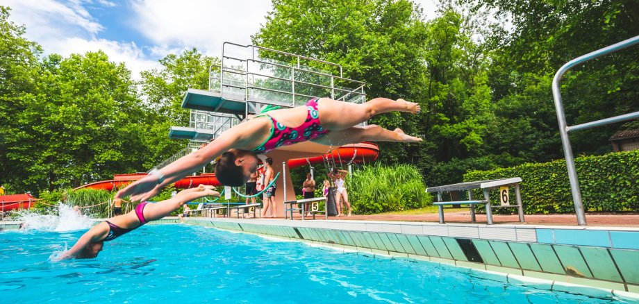 Children jump from the starting block into the water