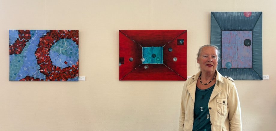 Ulrike Amsbeck in front of her paintings